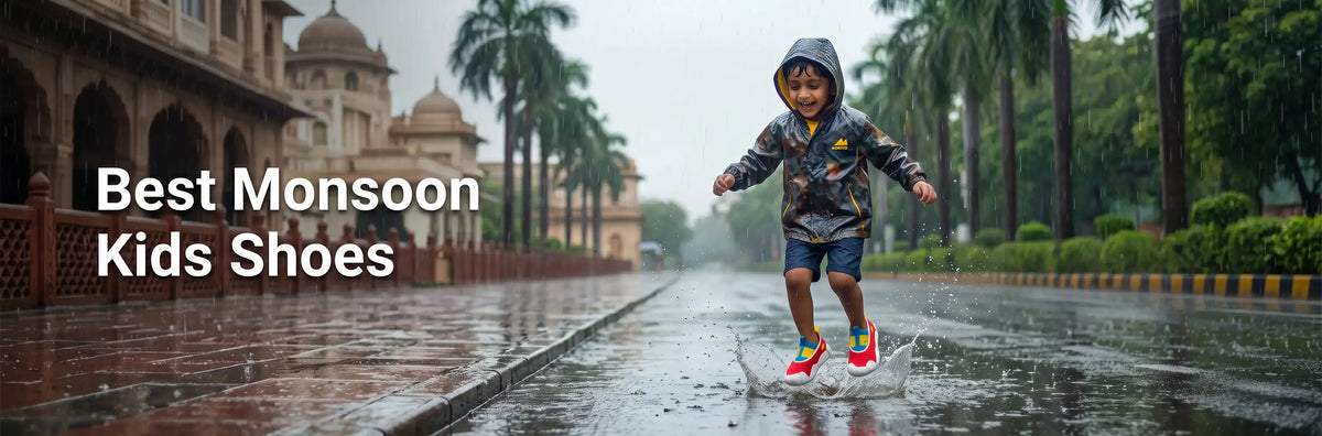 A young Indian boy in a rain jacket smiling and splashing in a puddle on a wet street during the monsoon season, wearing colorful Aretto kids' shoes.