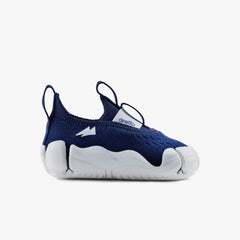 Side profile view of a single Aretto kids' shoe, highlighting the classic navy blue knit upper and ergonomic white sole. (Sizes S1 & S2)