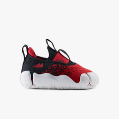 Side profile view of a single Aretto kids' shoe, highlighting the cosmic red knit upper and ergonomic white sole design. (Sizes S1 & S2)