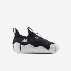Side profile view of a single Aretto kids' shoe, highlighting the classic black knit upper and ergonomic contrasting white sole. (Sizes S3 & S4)