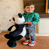 A Little Kid holding a teddy bear in hand wearing western outfit and Aretto kids stretchable shoes that grows up to 3 sizes